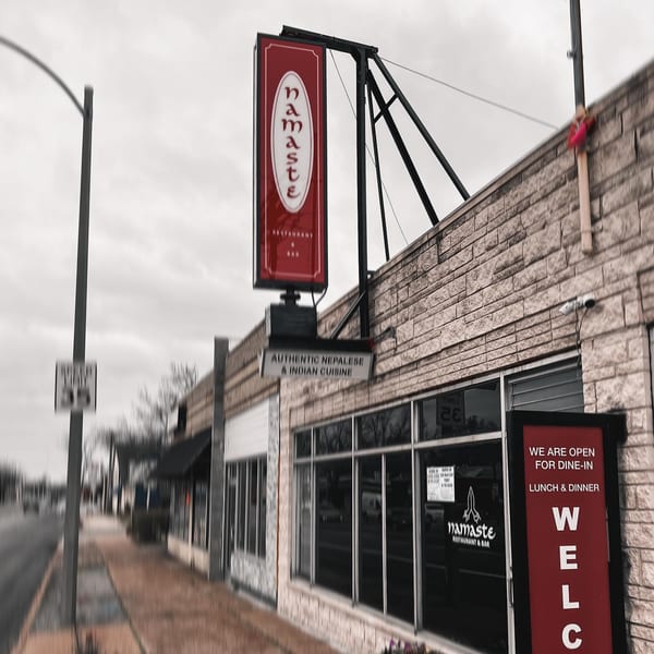 Exterior of Namaste Curry Lounge, an Indian and Nepalese restaurant, with a red vertical sign.