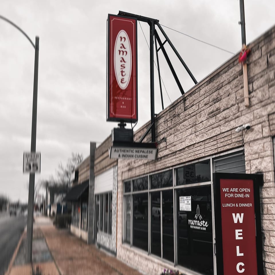Exterior of Namaste Curry Lounge, an Indian and Nepalese restaurant, with a red vertical sign.