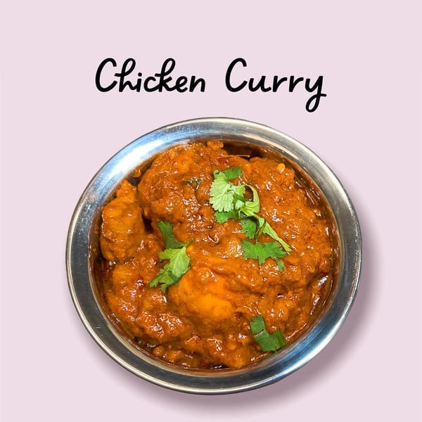 Namaste Curry Lounge's Indian Chicken Curry, a rich orange dish garnished with fresh cilantro in a metal bowl.